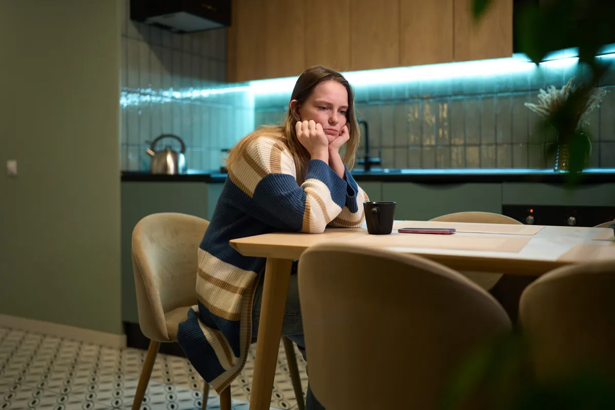 Kiégésben szenvedő fiatal nő az étkezőasztalánál