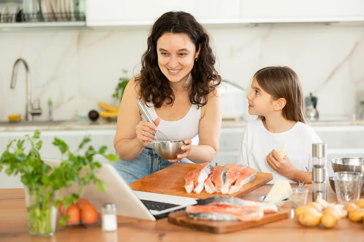 Anya és lánya gyulladáscsökkentő ételek, köztük lazac készítése közben