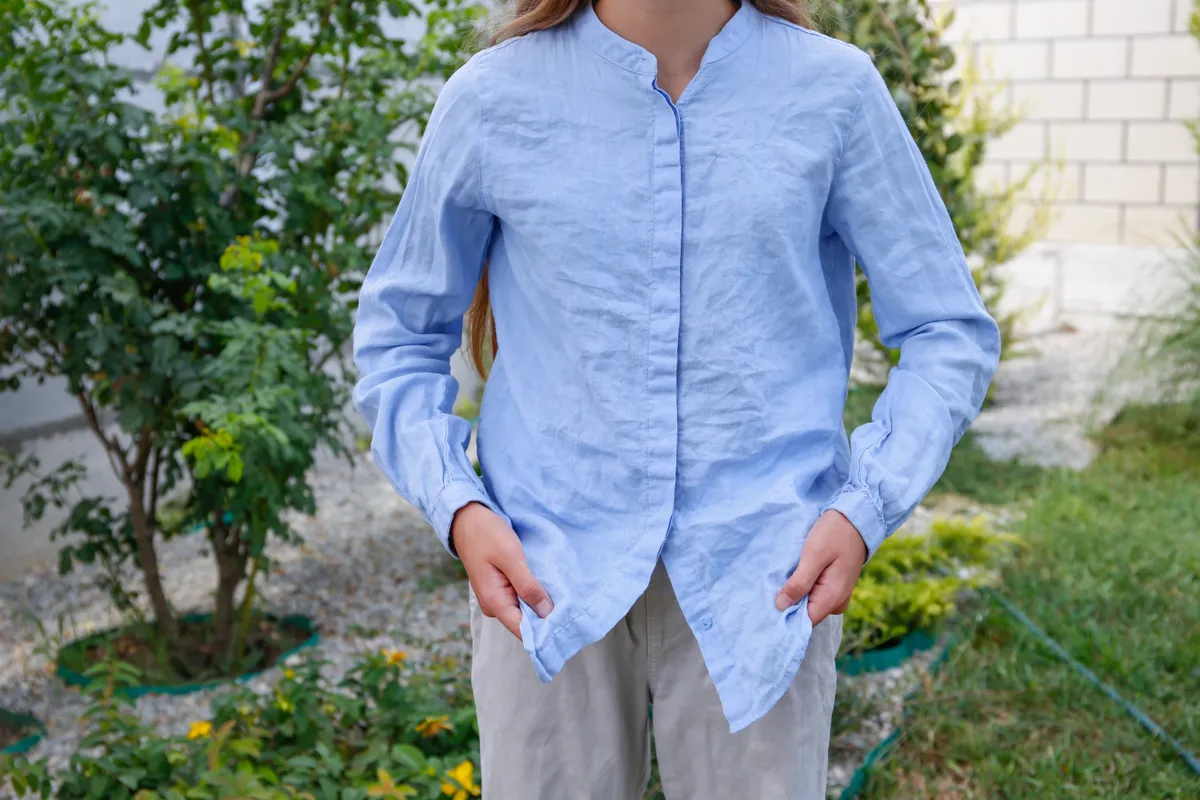 Tavaszi divat szerint öltözködő nő gyűrt ingben.