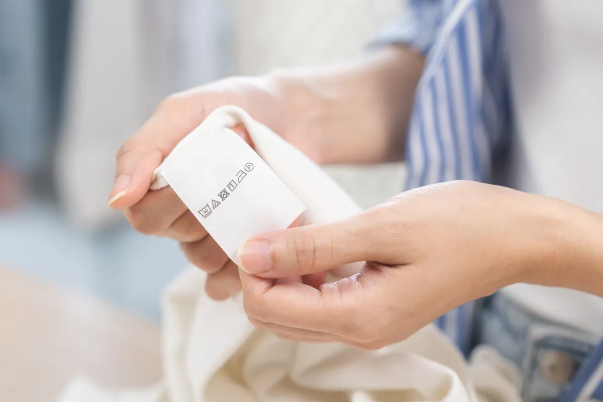 A kvízben szereplő ruhacímke, amit egy nő tanulmányoz.