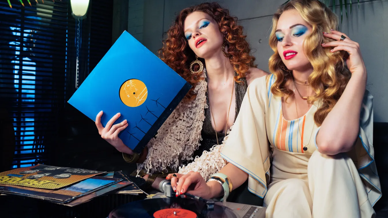 Két lány régi lemezeket hallgat a retró kvízben.