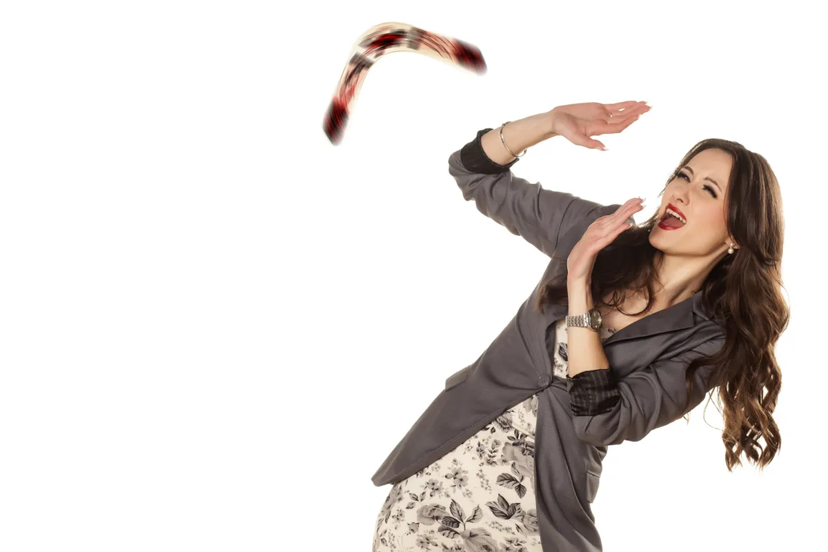 Védekező nőhöz visszatérő bumeráng a karma működésének következtében