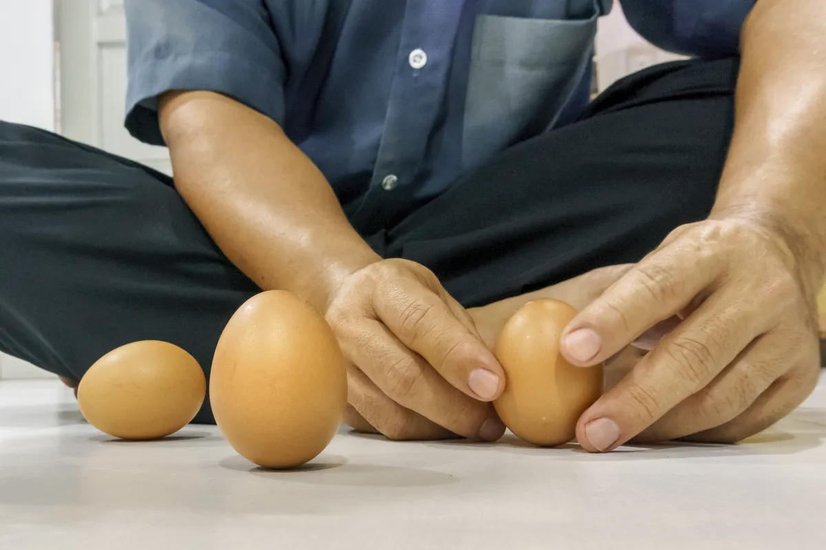 Tojásokat állító férfi a nap-éj egyenlőség idején.