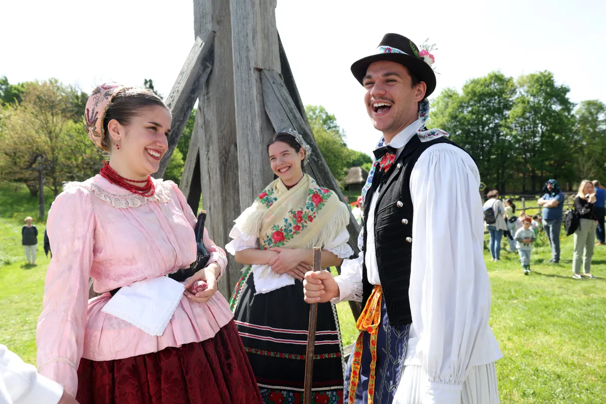Magyar népviseletbe öltözött fiatalok locsolóvers kvízt oldanak meg. 