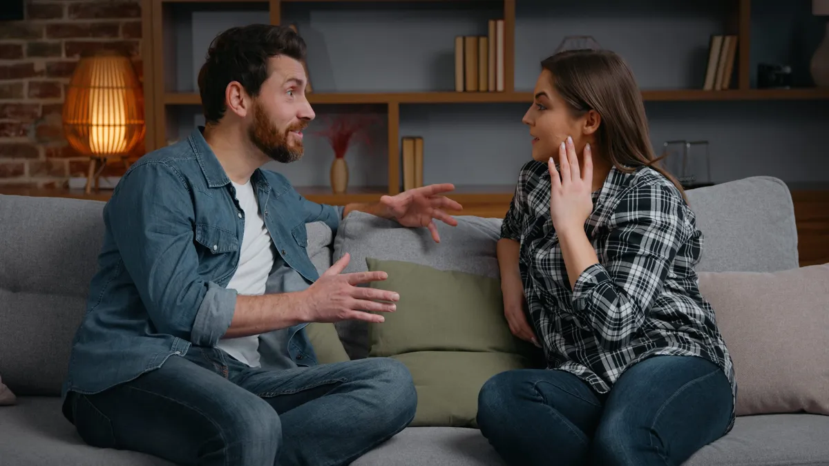 A társas magányról beszélgető pár ül a kanapén.