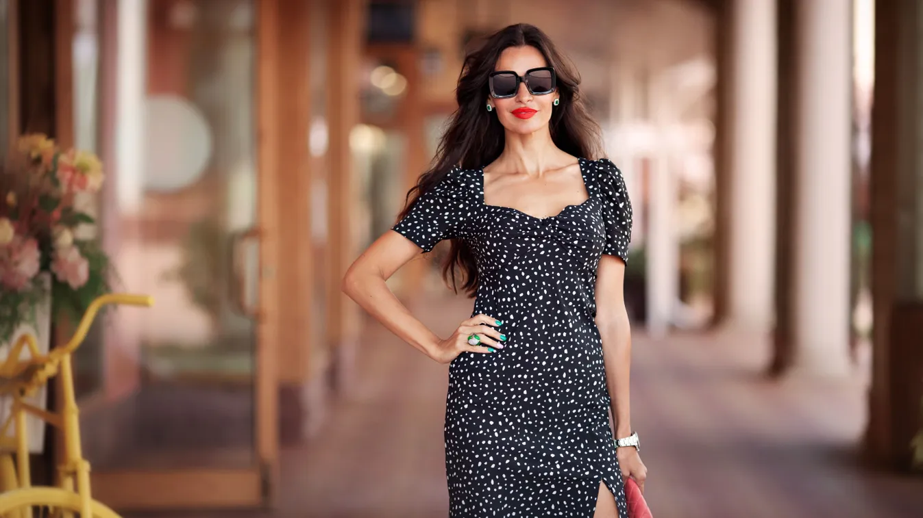 Negyven év feletti nő fekete alapon fehér pöttyös ruha viselése közben