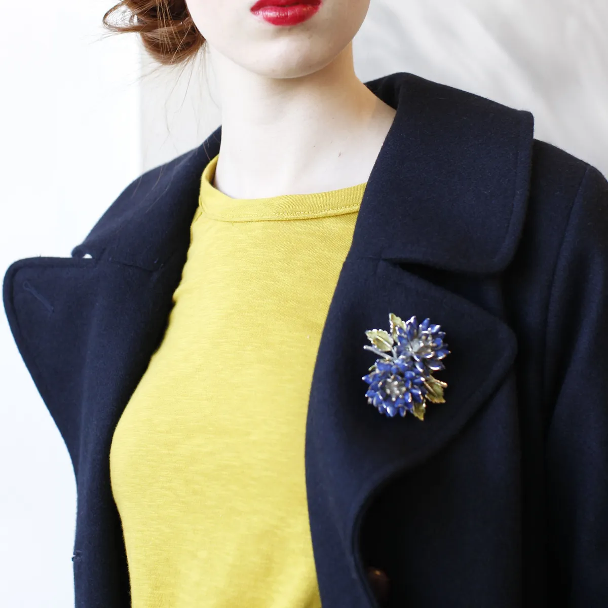 Virágos kiegészítőt, vagyis brosst viselő nő.