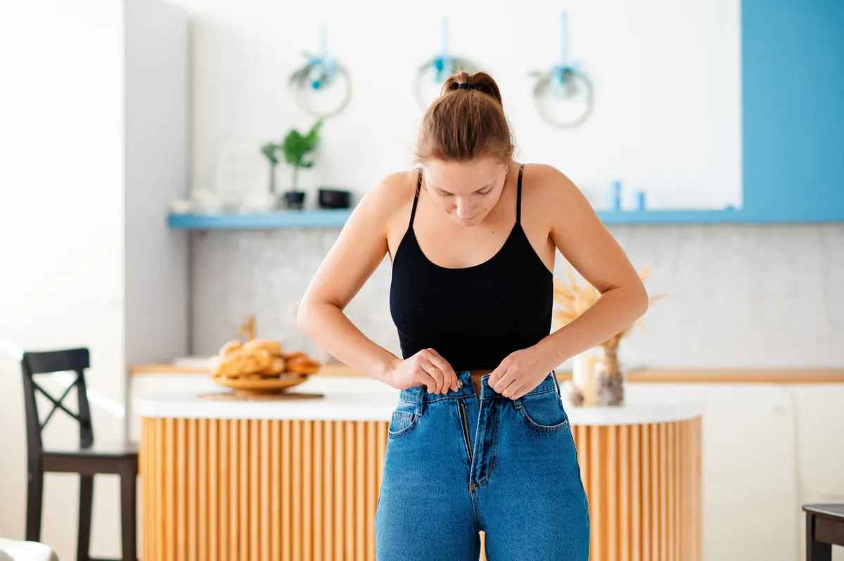 Összement ruha problémájával küzdő fiatal nő.