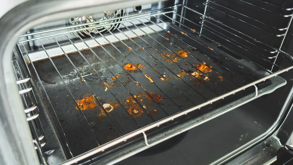 Sütő tisztítás elhanyagolása miatt ráégett zsírréteg a sütőn.