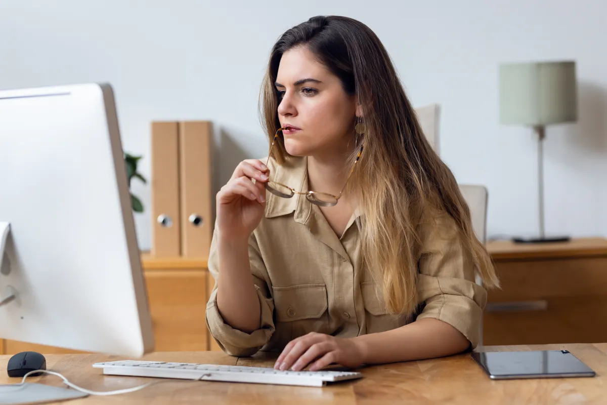 Okos fiatal nő ül a gép előtt a horoszkópban.