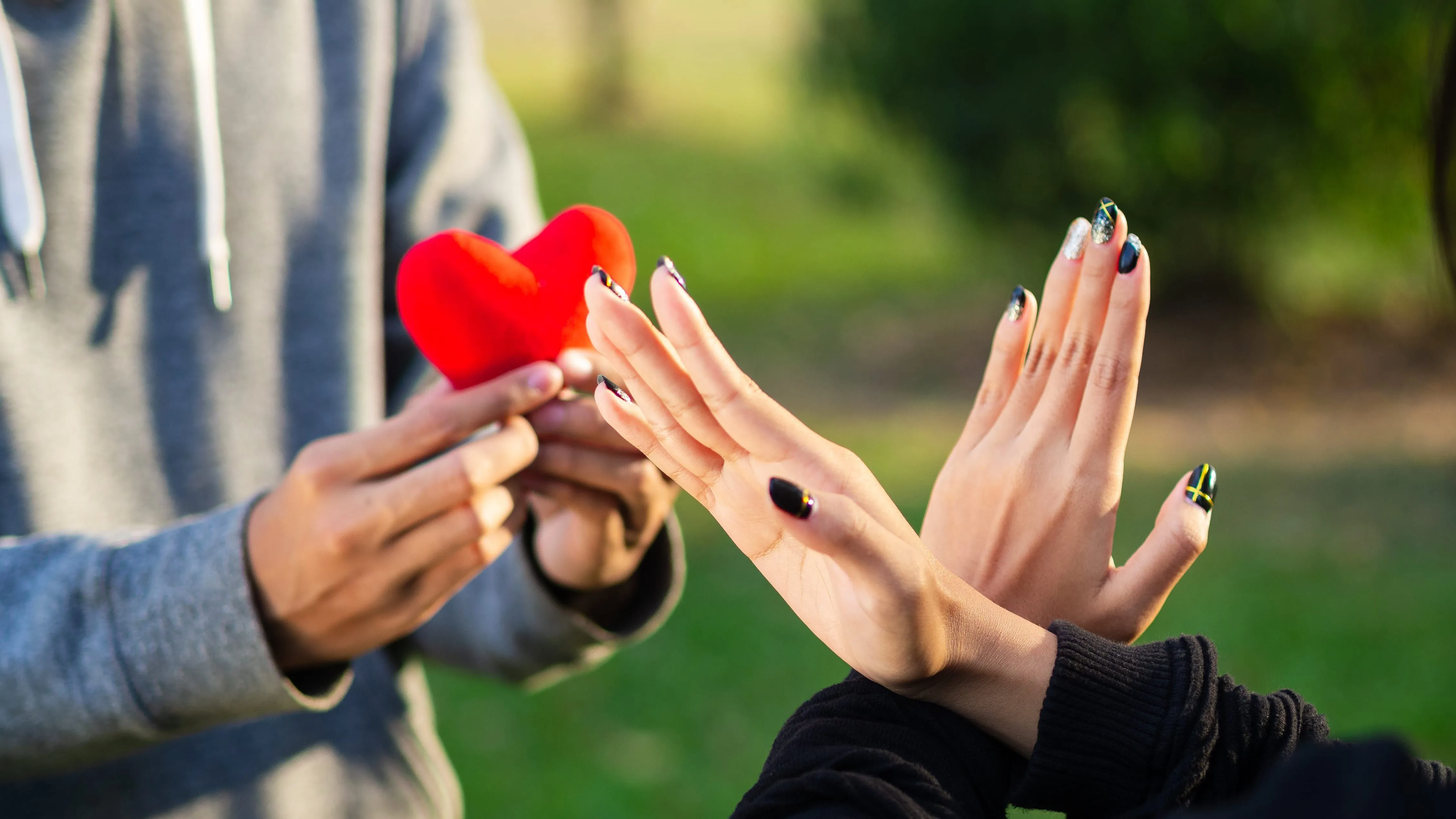Egy fiatal nő felé nyújtott szív alakú plüssfigura elutasítása mint a társkeresés buktatóinak egyike