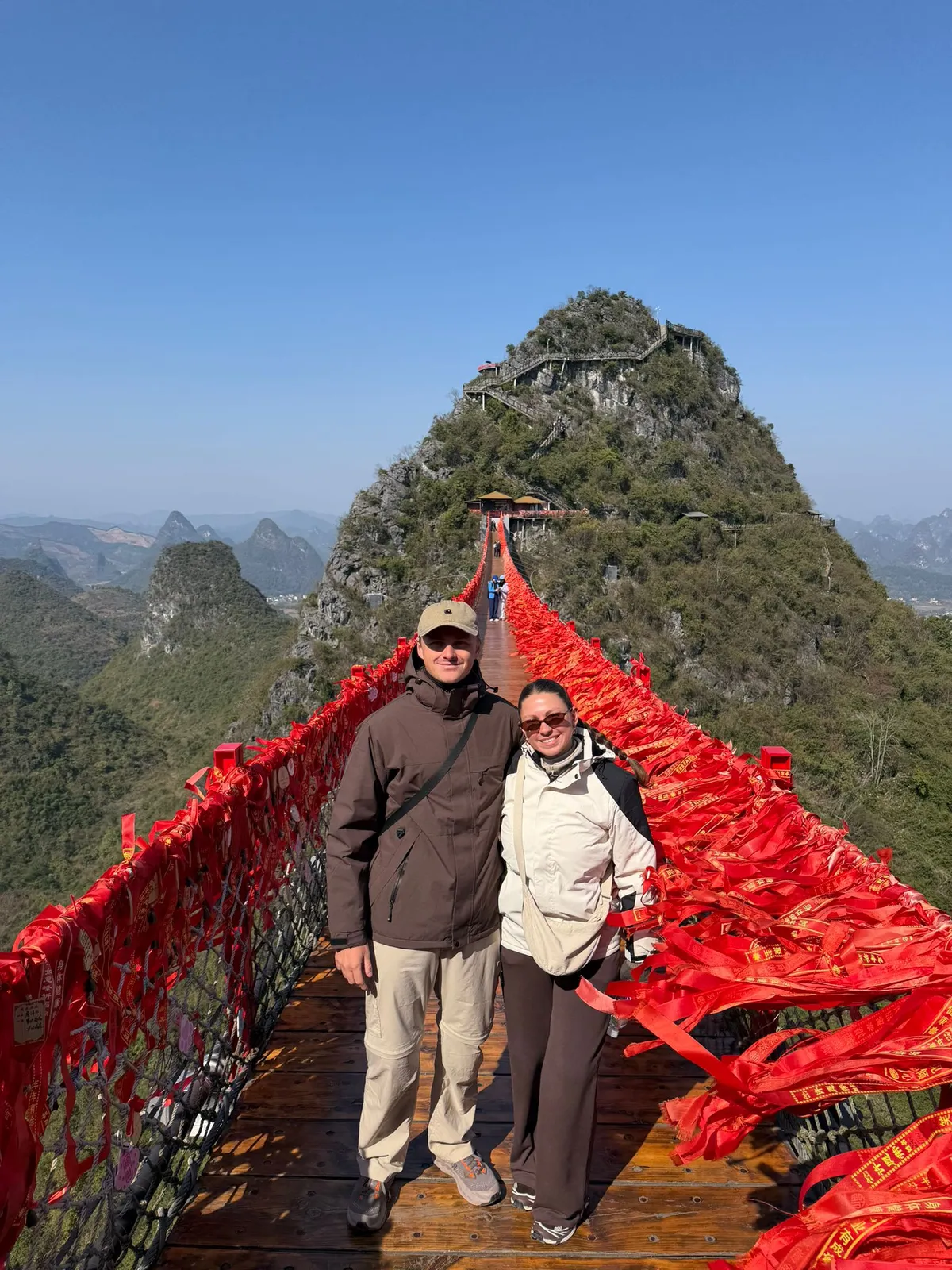 Gergő és Maxine a piros zszalagokkal teleaggatott Ruyi-hídnál, Kínában.