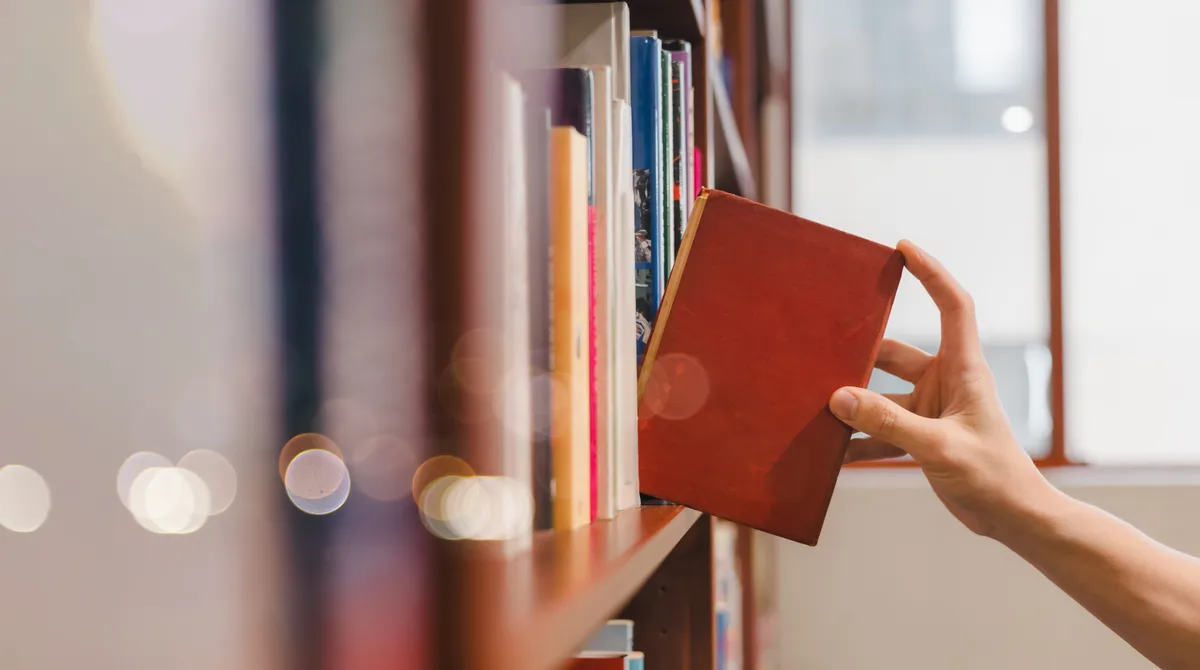 Könyvet emel le a polcról egy férfi az irodalmi kvízben.