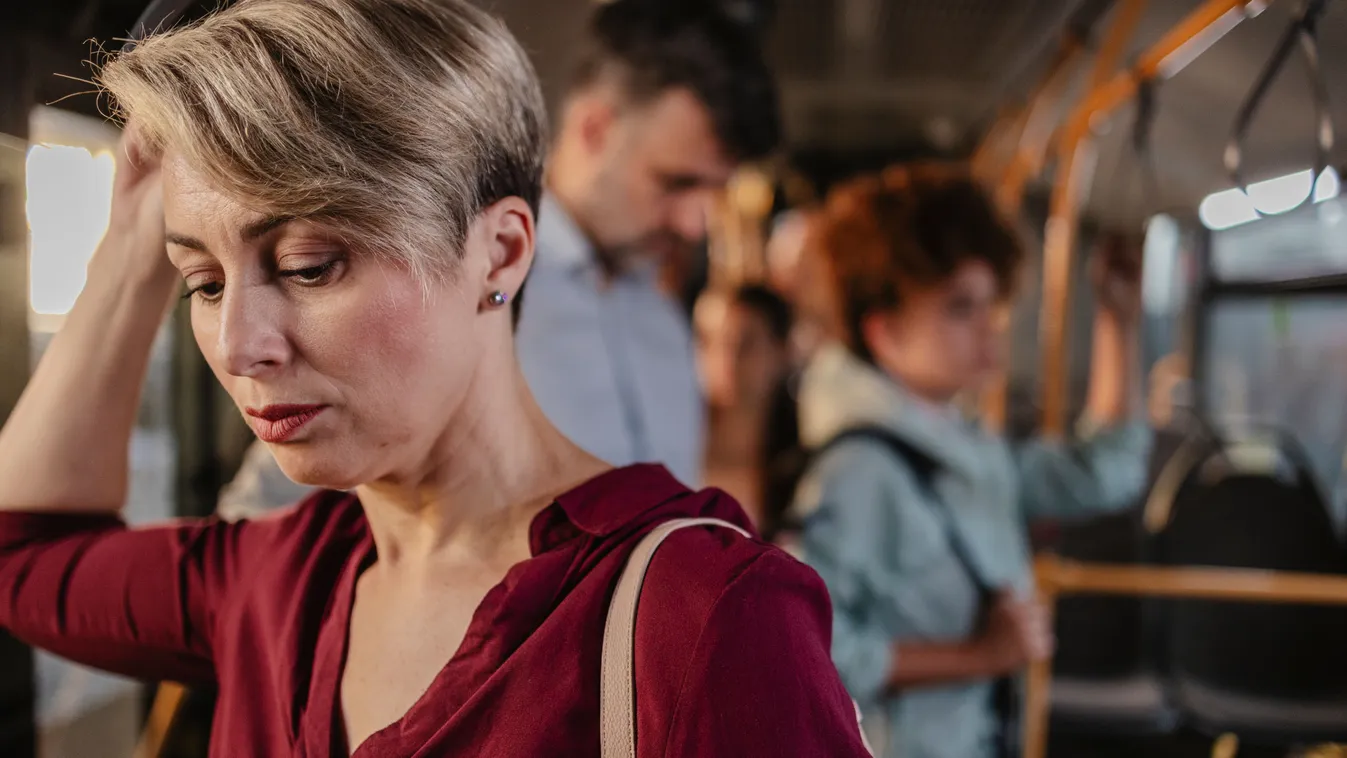 Fáradt nő utazik a buszon, akinek nincsenek bőrproblémái.