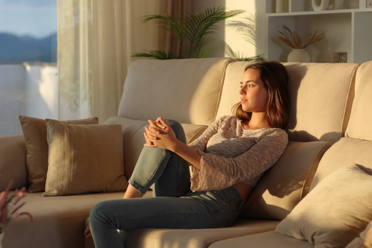 Pensive,Woman,At,Sunset,At,Home,Looking,Away,Sitting,On