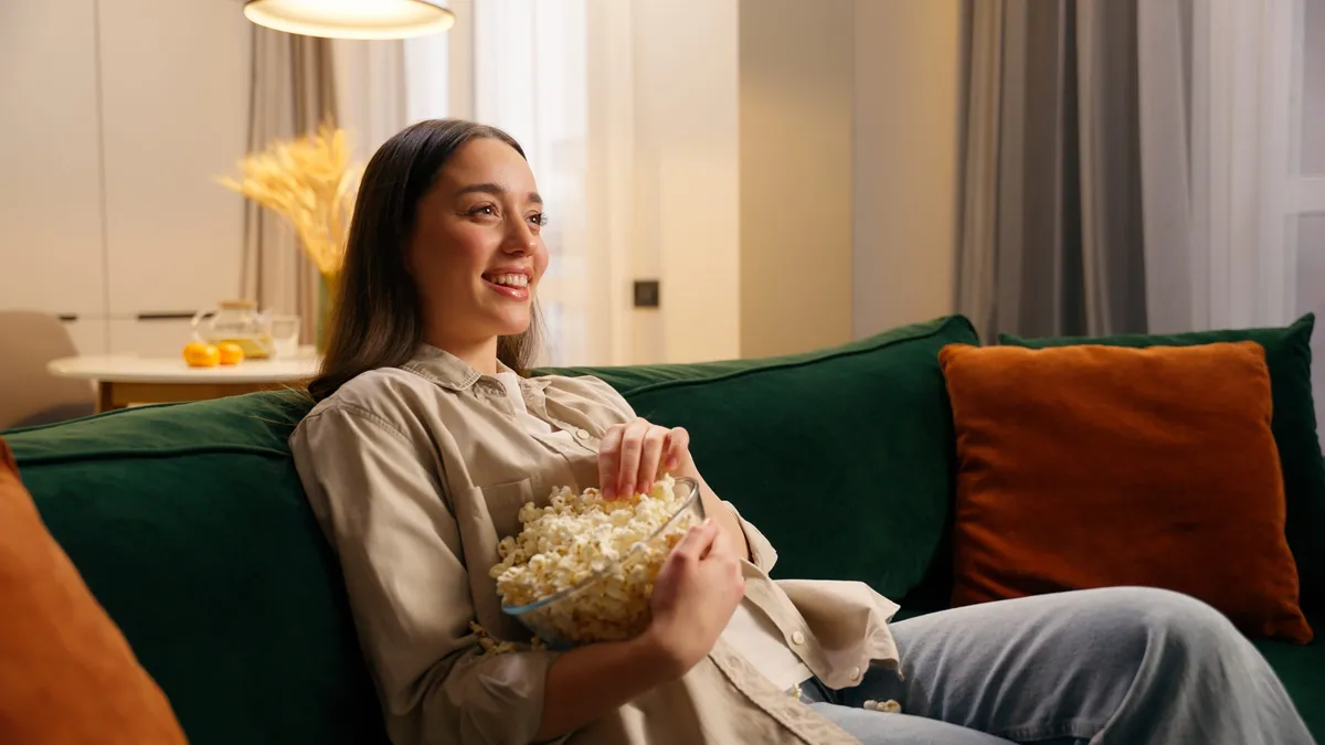 Popcornnal mozizó fiatal nő a kanapén a Tarantino-kvízben.