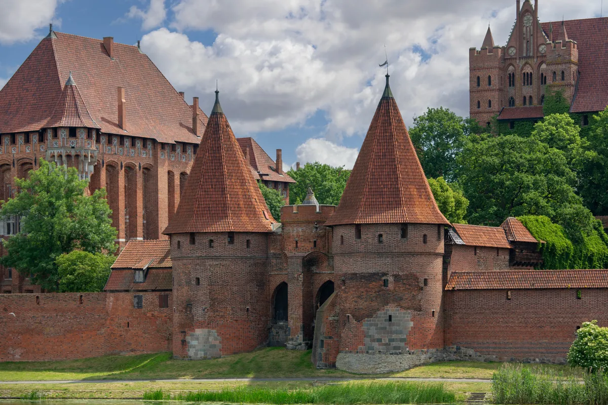 A lengyelországi Malbork vára a folyó felől fotózva.