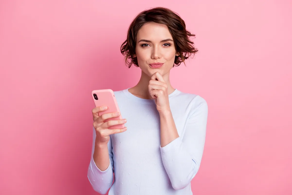 Személyiségtesztet töltő nő telefonnal a kezében.