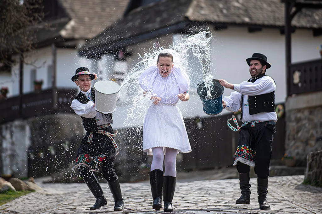 A hollókői néptánccsoport tagjai palóc népviseletben locsolkodnak a hollókői ófaluban tartott sajtórendezvényen. A településen a járványügyi helyzet miatt nem rendezik meg a húsvéti fesztivált. 
20210401 Hollókő Fotó: Ladóczki Balázs LB Nógrád Megyei Hírl
