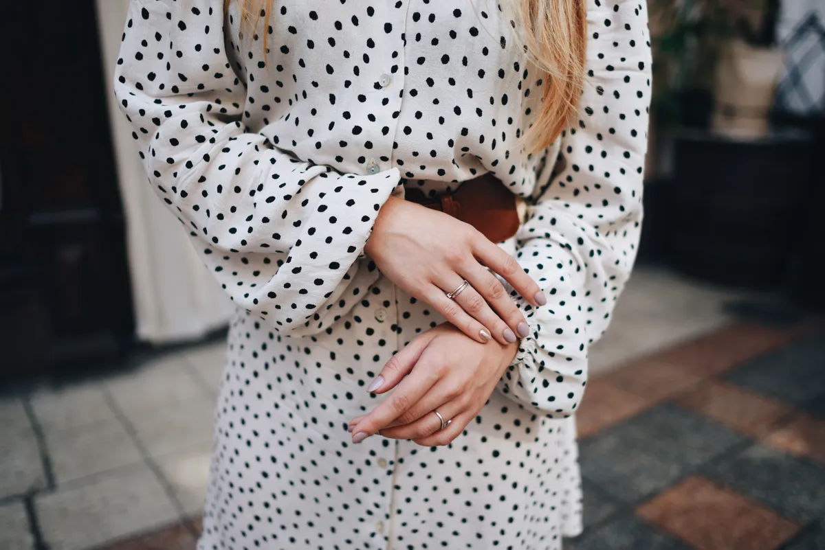 Elegáns nő pöttyös ruha viselése közben
