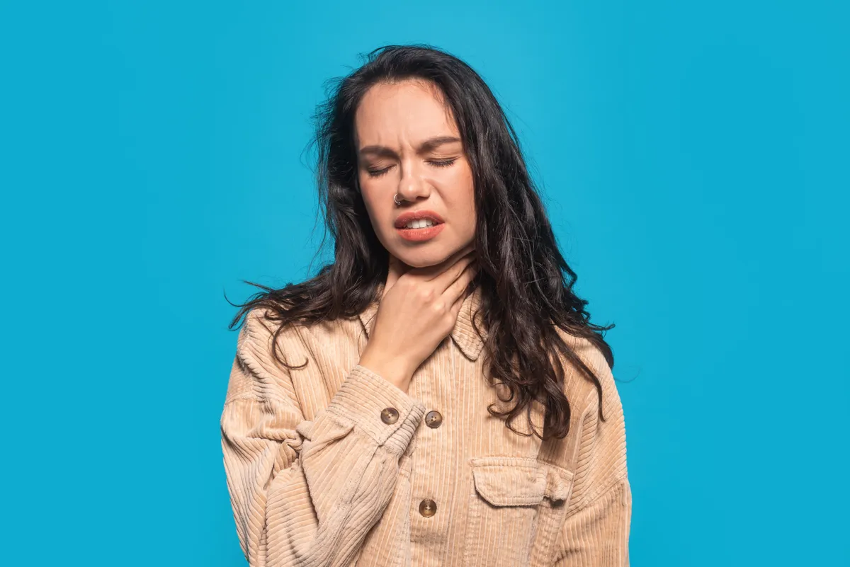 Refluxos tünetek miatt a torkához kapó fiatal nő