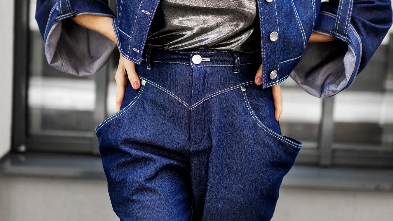 Stílusos farmernadrágot viselő középkorú nő.