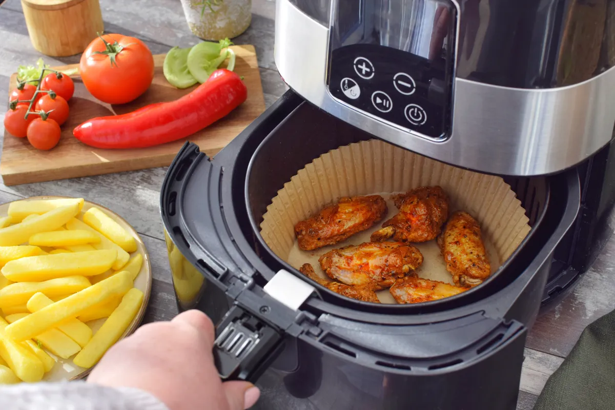 Air fryer tisztítása mosogatógép-tablettával csirkeszárnysütés után.