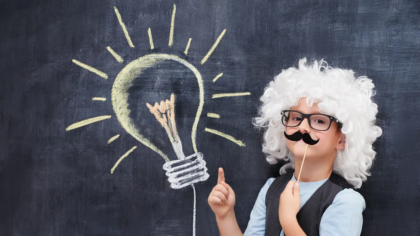 Einstein parókában a tábla előtt álló fiú a matek kvízben.