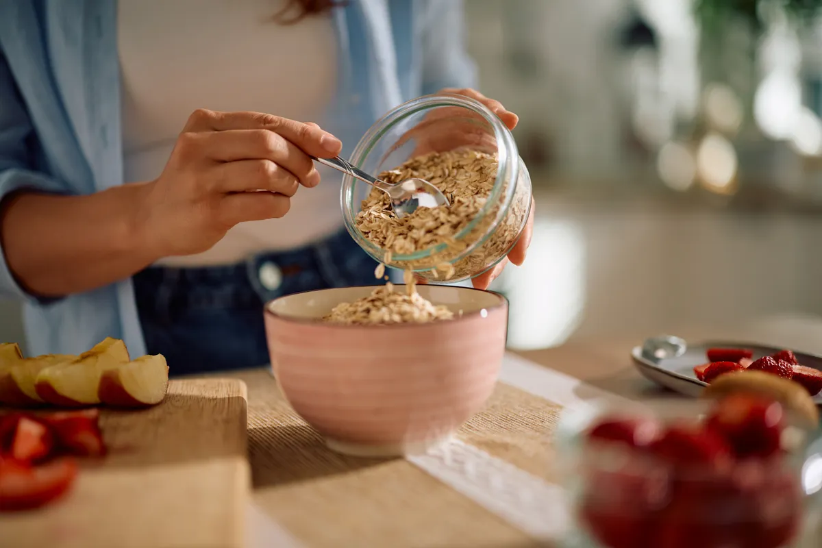 Zabkását készítő nő, mivel a zab tökéletes reflux diéta alatt.