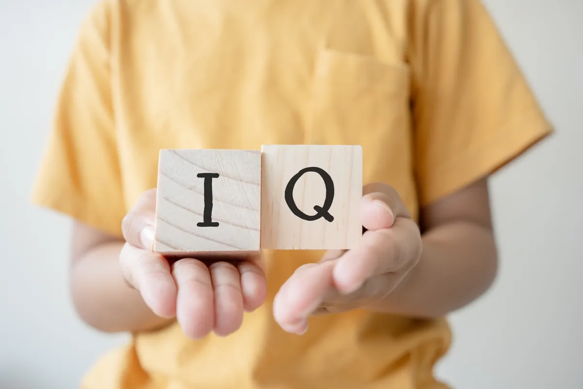 IQ-tesztben szereplő kéz, amely két fakockát tart.