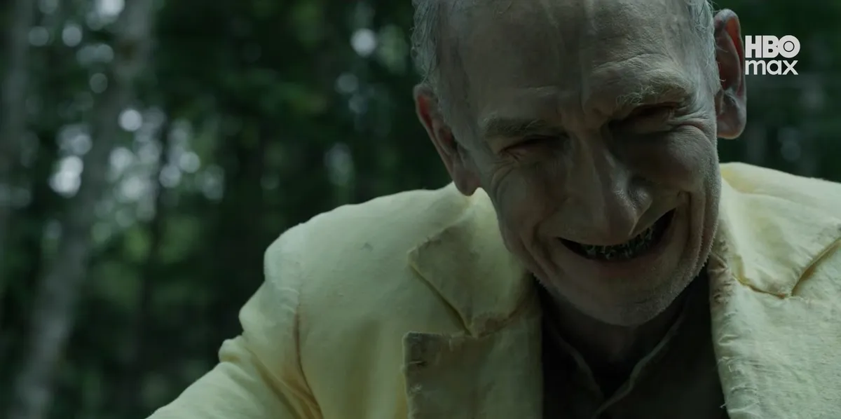 A Kiút sorozat sárga ruhás férfija riasztóan mosolyog.