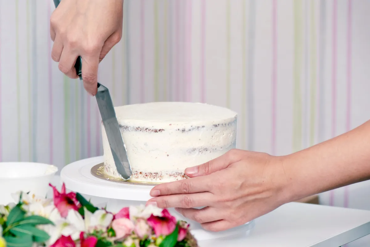 Egy nő esküvői torta készítése közben.