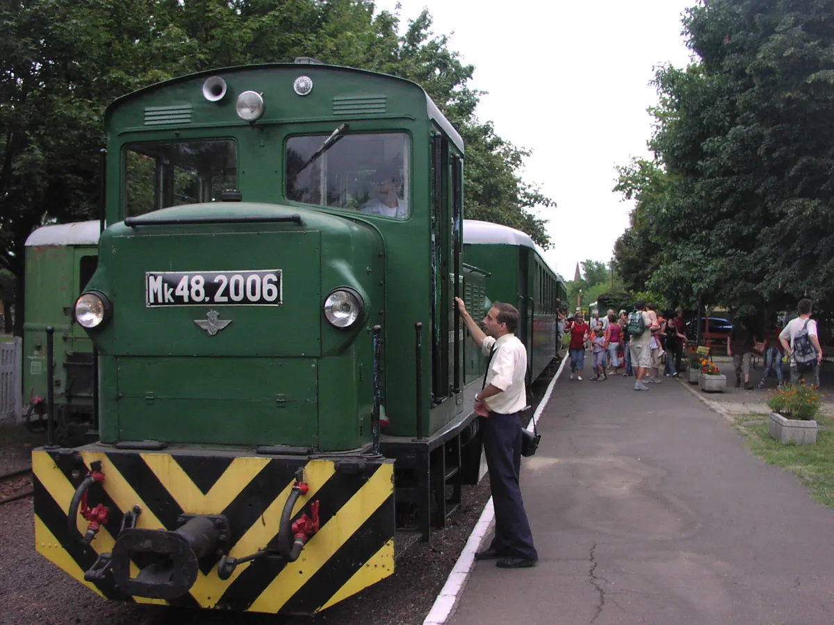 A debreceni Zsuzsi vonat mozdonya, mellette kirándulók.