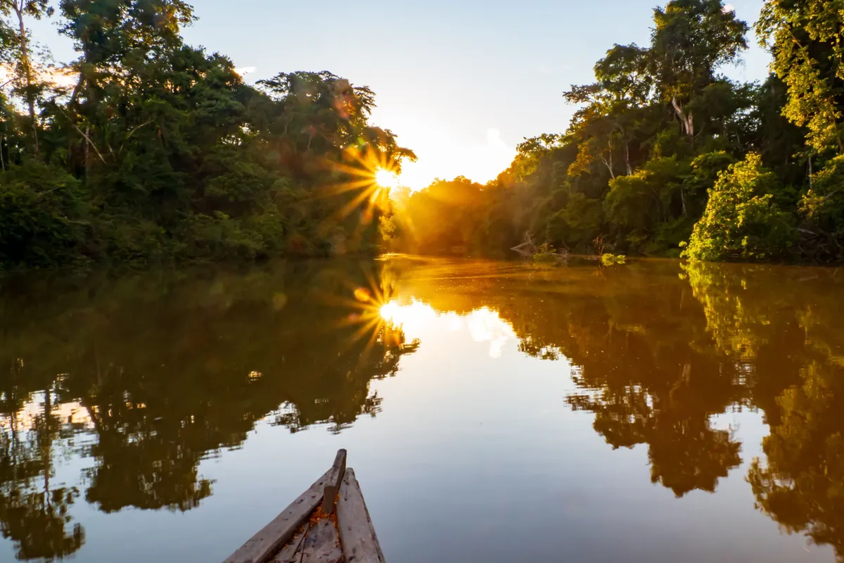 Amazonasi folyó csónakról fotózva naplemente idején.