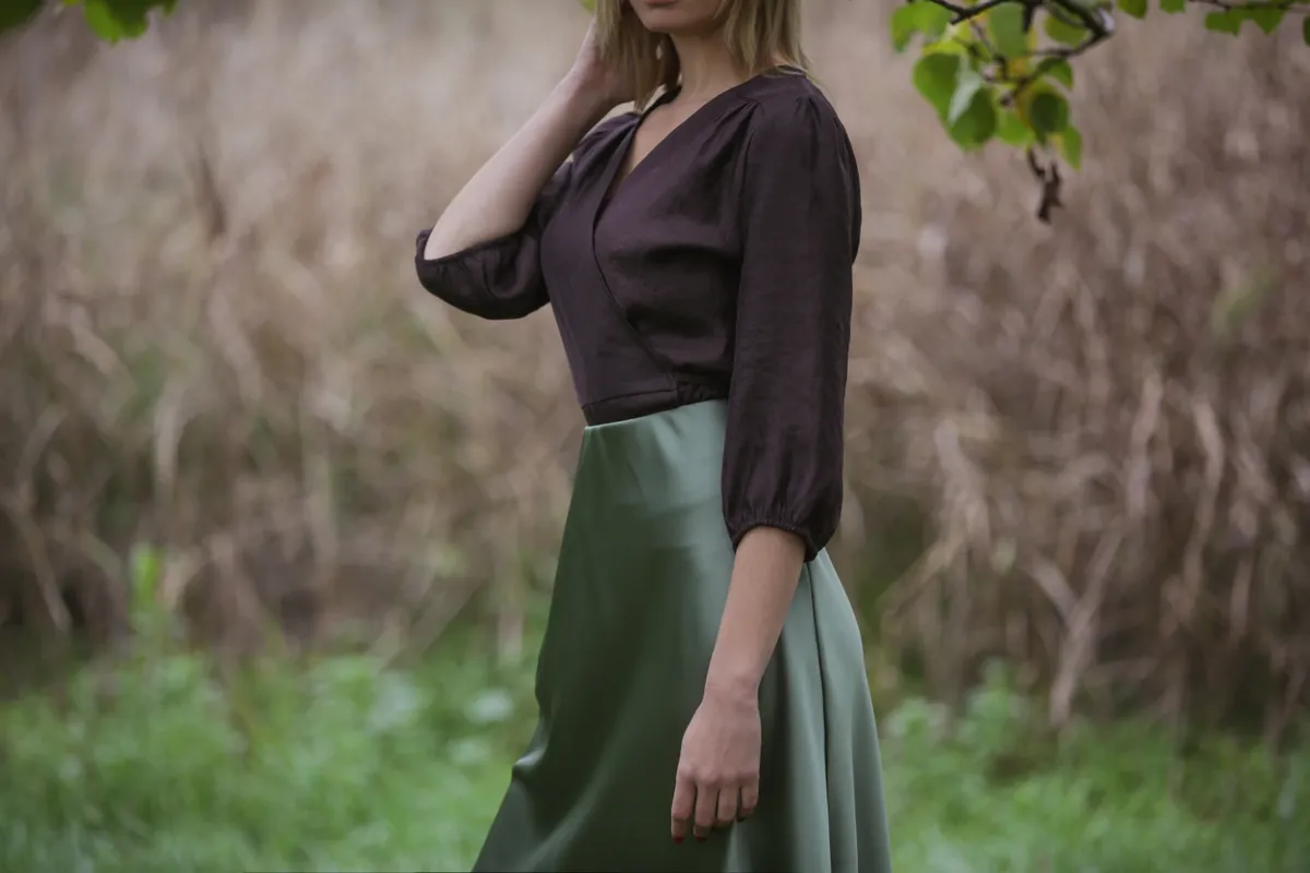 Egy elegáns nő, akin zöld szaténszoknya látható.