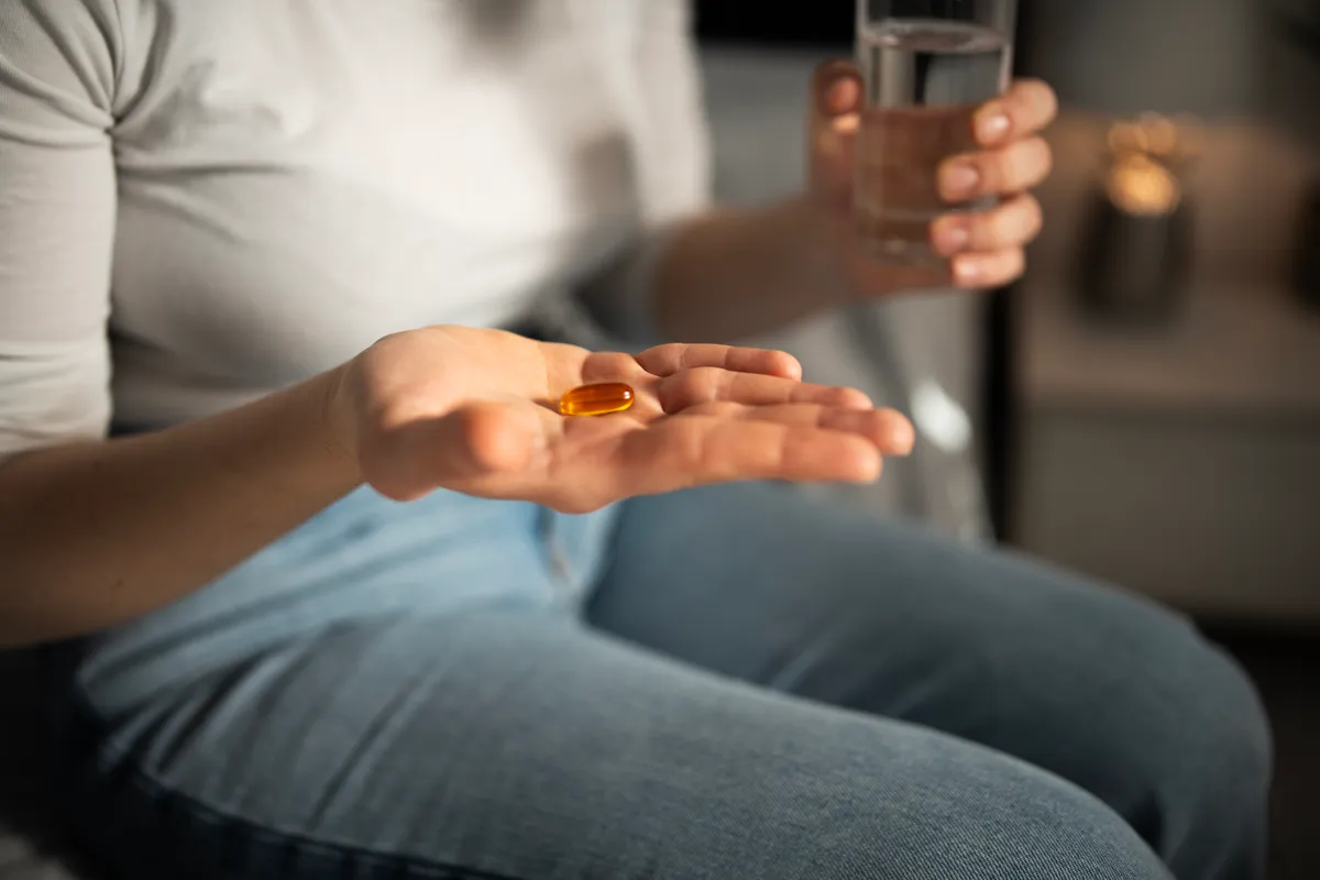 Vitaminkapszula egy nő kezében