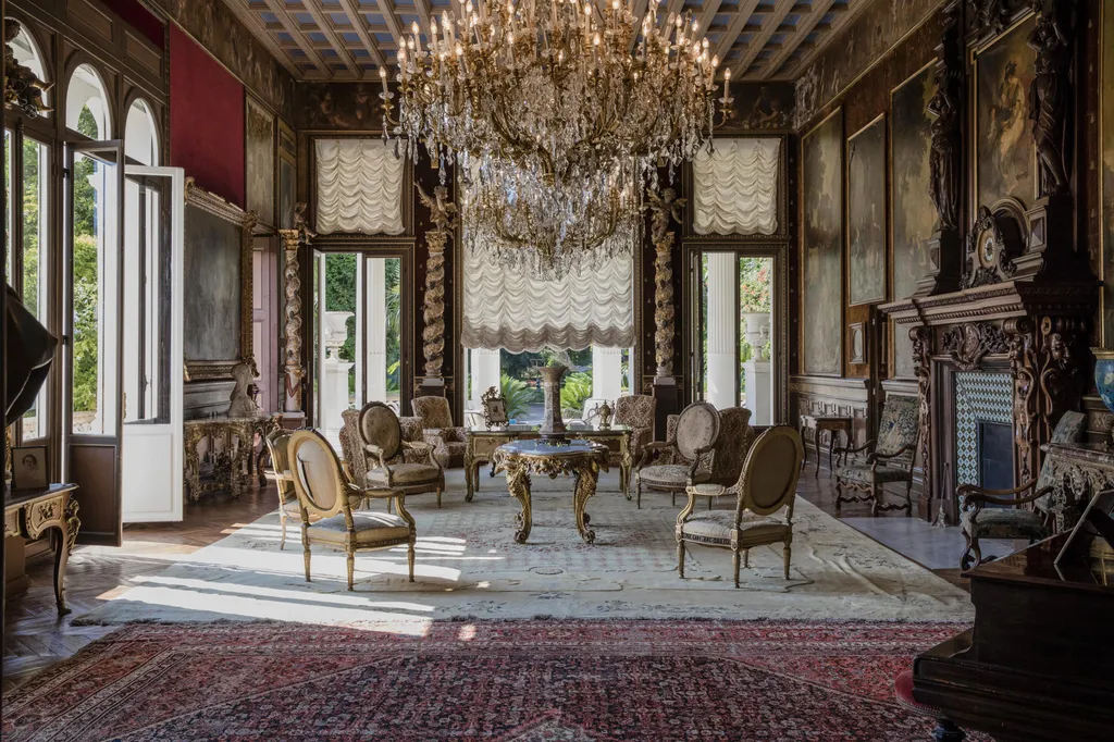 Armchairs and tables stand beneath chandeliers as 19th century portraits in ornate frames adorn the walls of a sitting room inside the Villa Les Cedres, a 187-year-old, 18,000-square-foot, 14-bedroom mansion set on 35 acres, in Saint-Jean-Cap-Ferrat, Fran