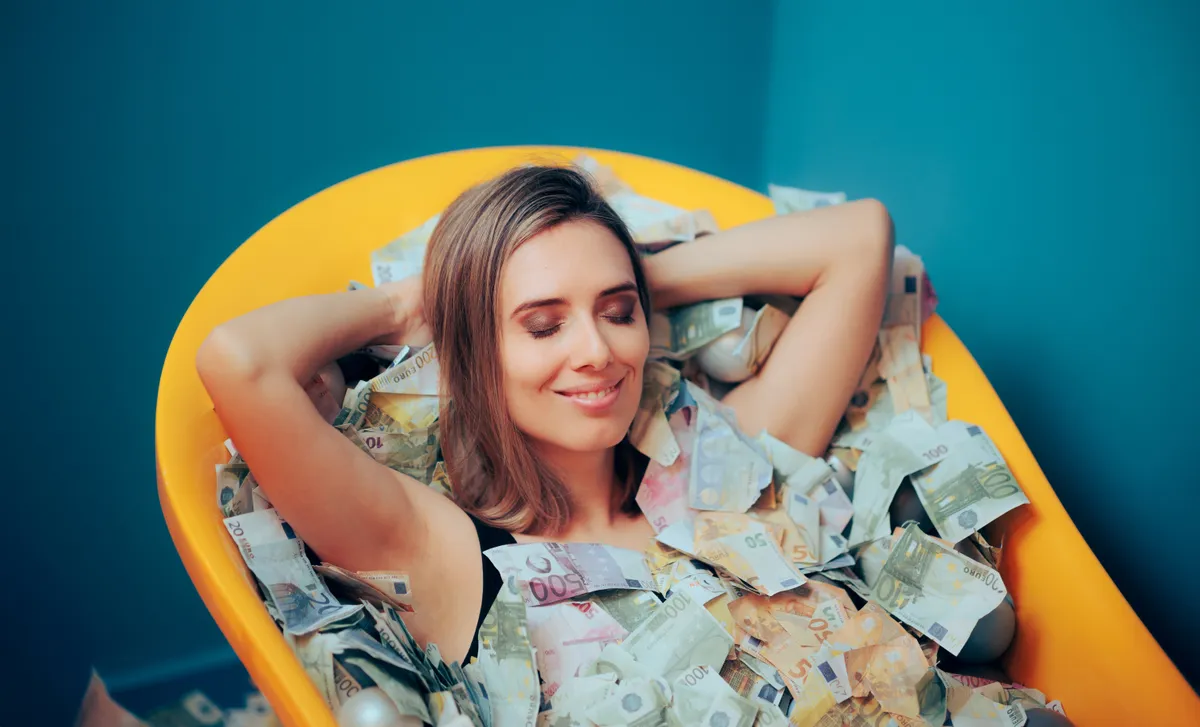 Egy nő sárga, eurókkal teli fürdőkádban fekszik, tudja mi a siker titka. 