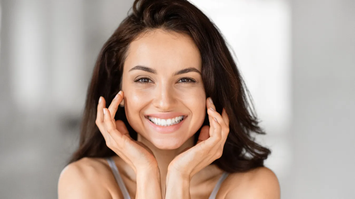 Mosolygó fiatal nő, aki kókuszolajos öblögetést használ.