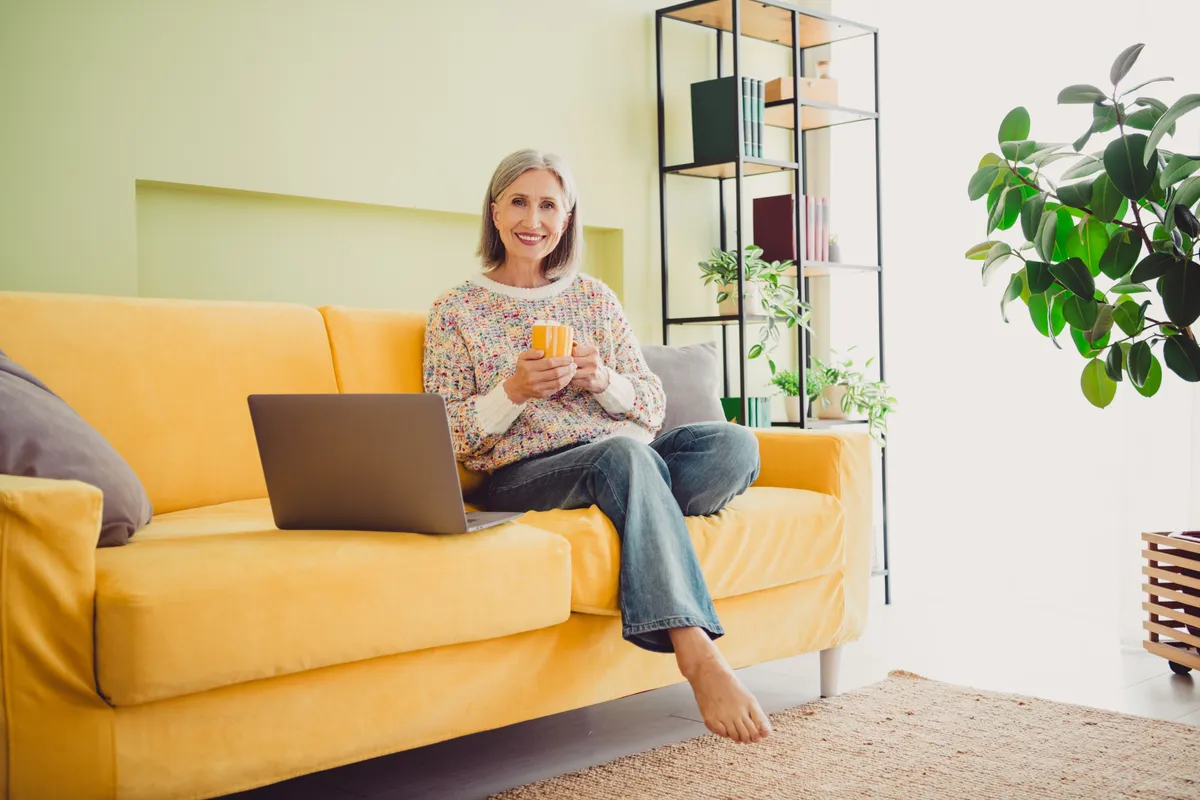 sárga kanapén ül középkorú nő