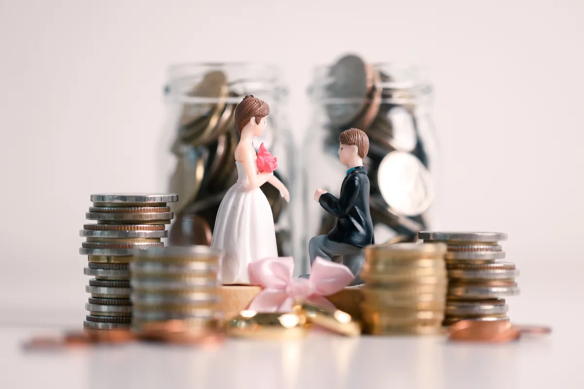 Házasság vagy élettársi kapcsolat: menyasszony é vőlegény figura pénzérmék között