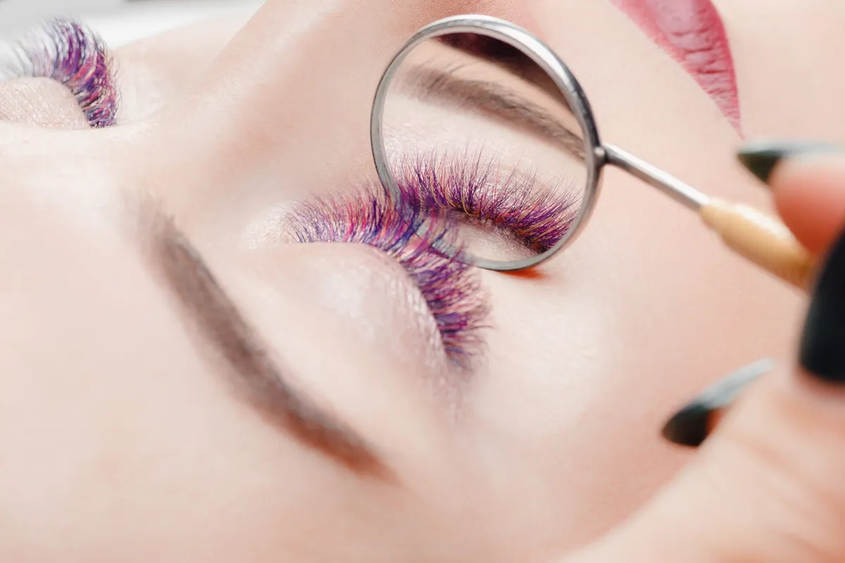 Színes műszempillát viselő nő.