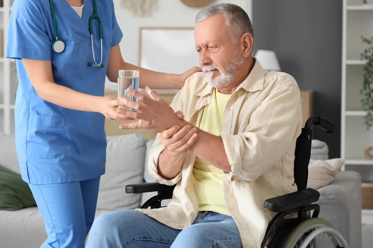 Parkinson-kórban szenvedő idős férfi és az ápolója.