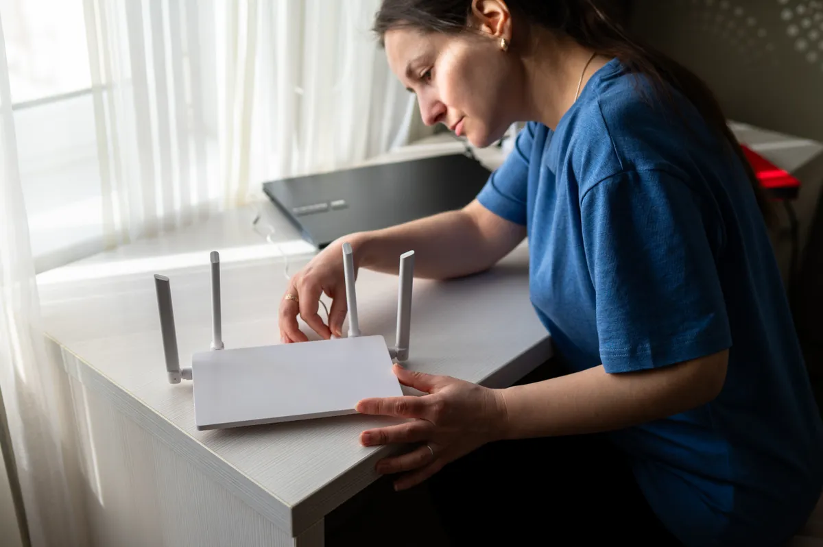 Lassú Wi-Fi routert nézegető nő.