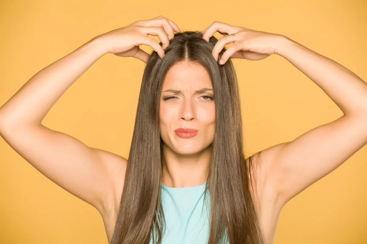 Korpa elleni házi praktikákon gondolkodó nő fejvakarás közben