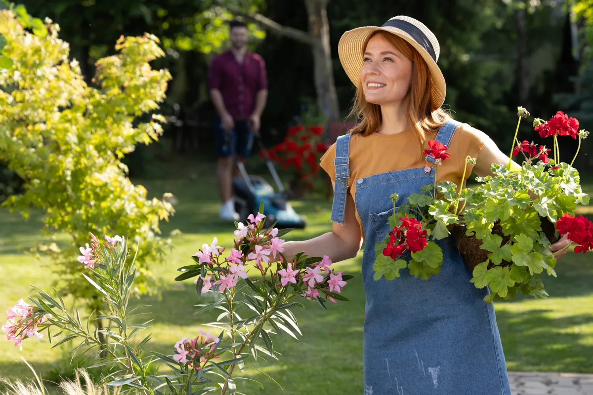 Muskátlit a kezében tartó nő 
