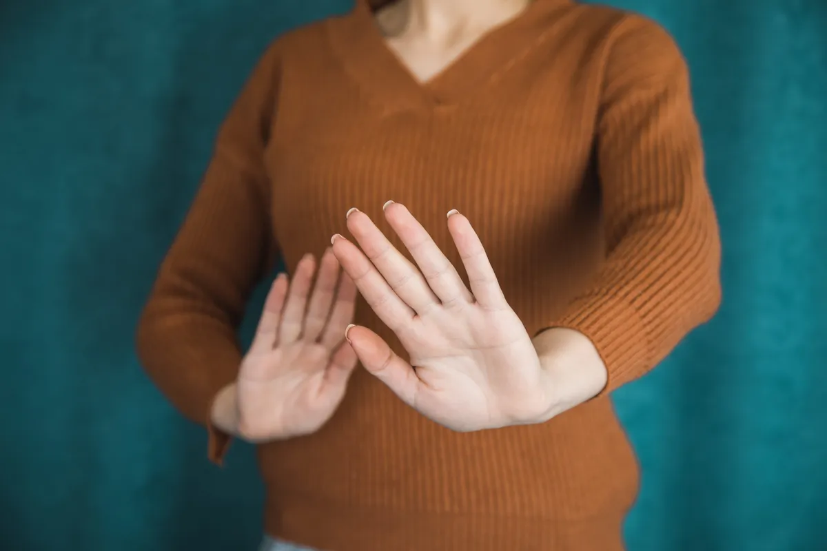 Egy nó, aki a kezével nemet mutat, mert van egészséges önbecsülése.