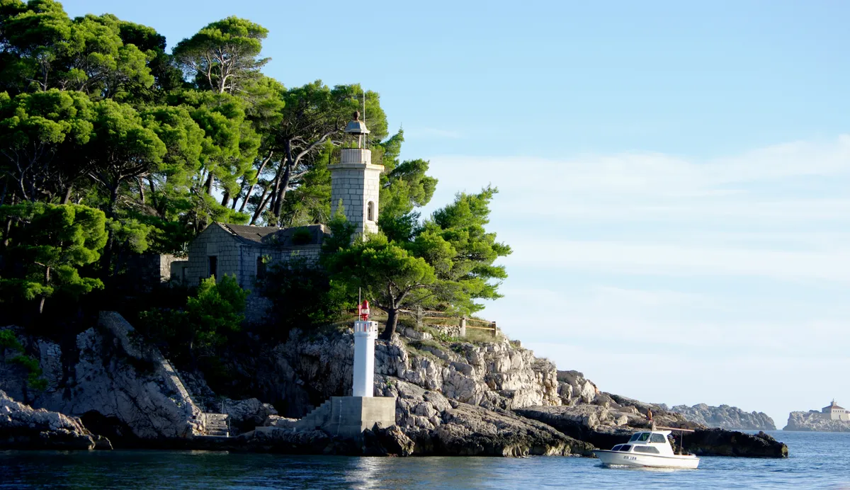 A horvátországi Daksa sziget világítóornya és egy yacht.