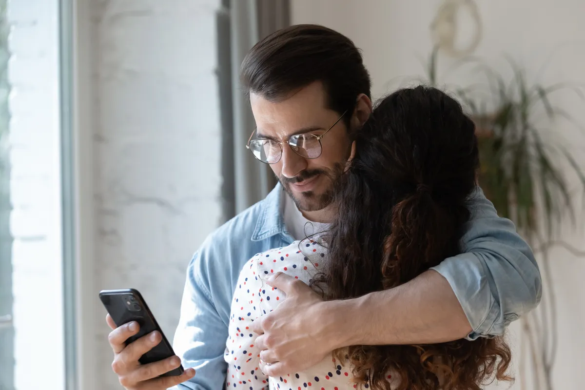 Hűtlen férfi a telefonját nézi ölelés közben a kínai horoszkópban.