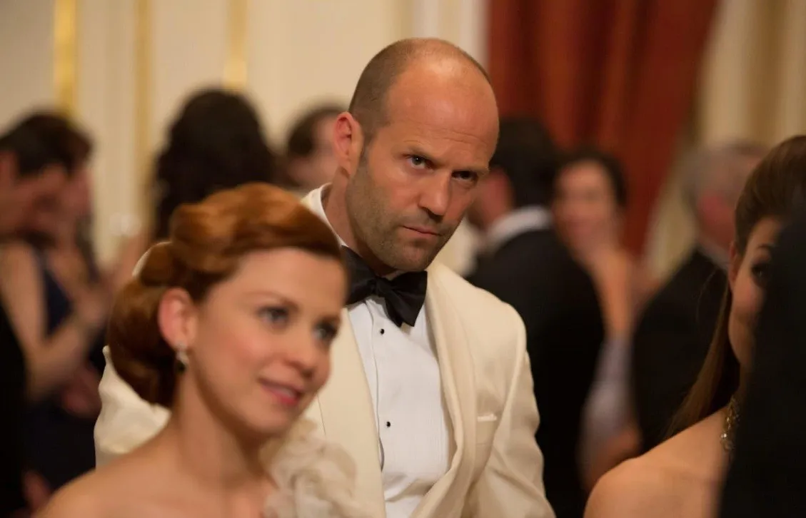 Jason Statham a kém című filmben, krém színű öltönyében.